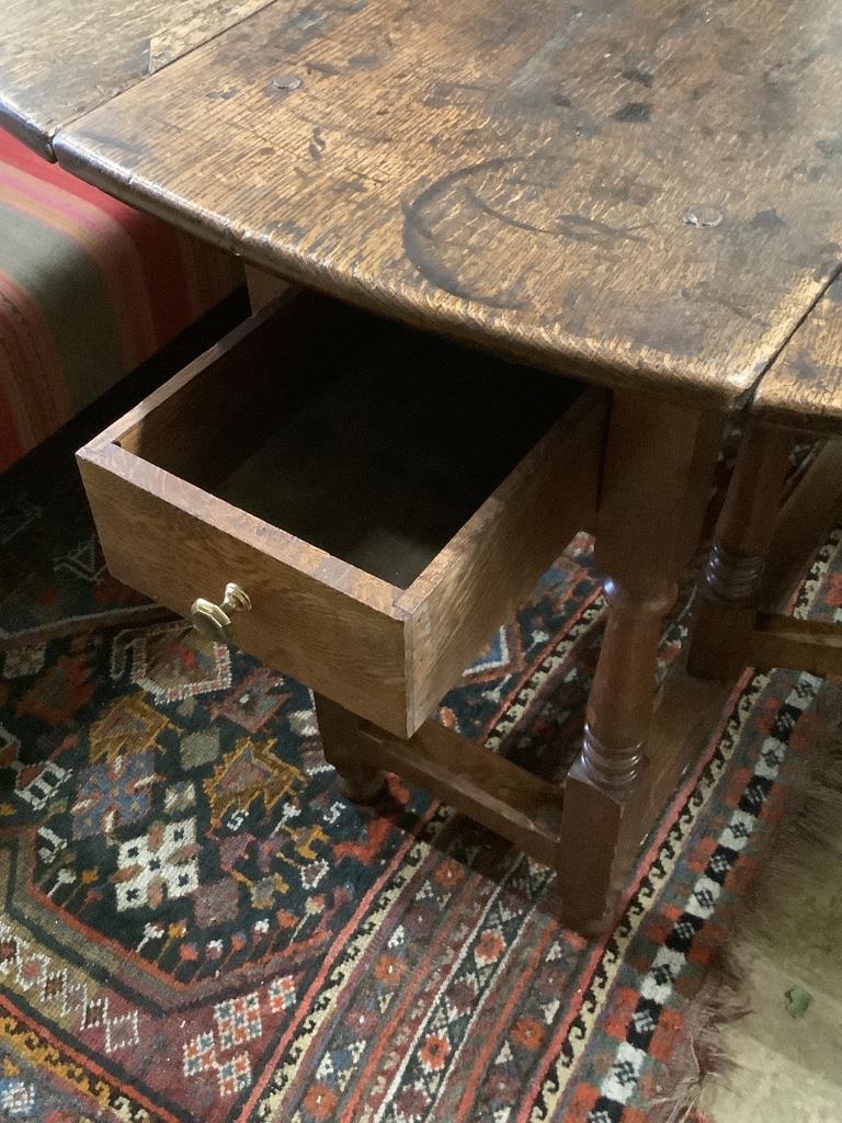 A mid 18th century oak oval topped gate leg dining table, fitted one drawer